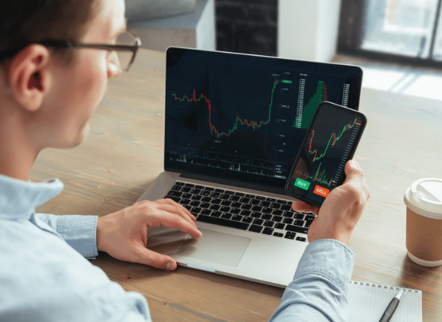 Stanislav_Kondrashov_TELF_AG_trader_using_laptop_and_phone_charts_5